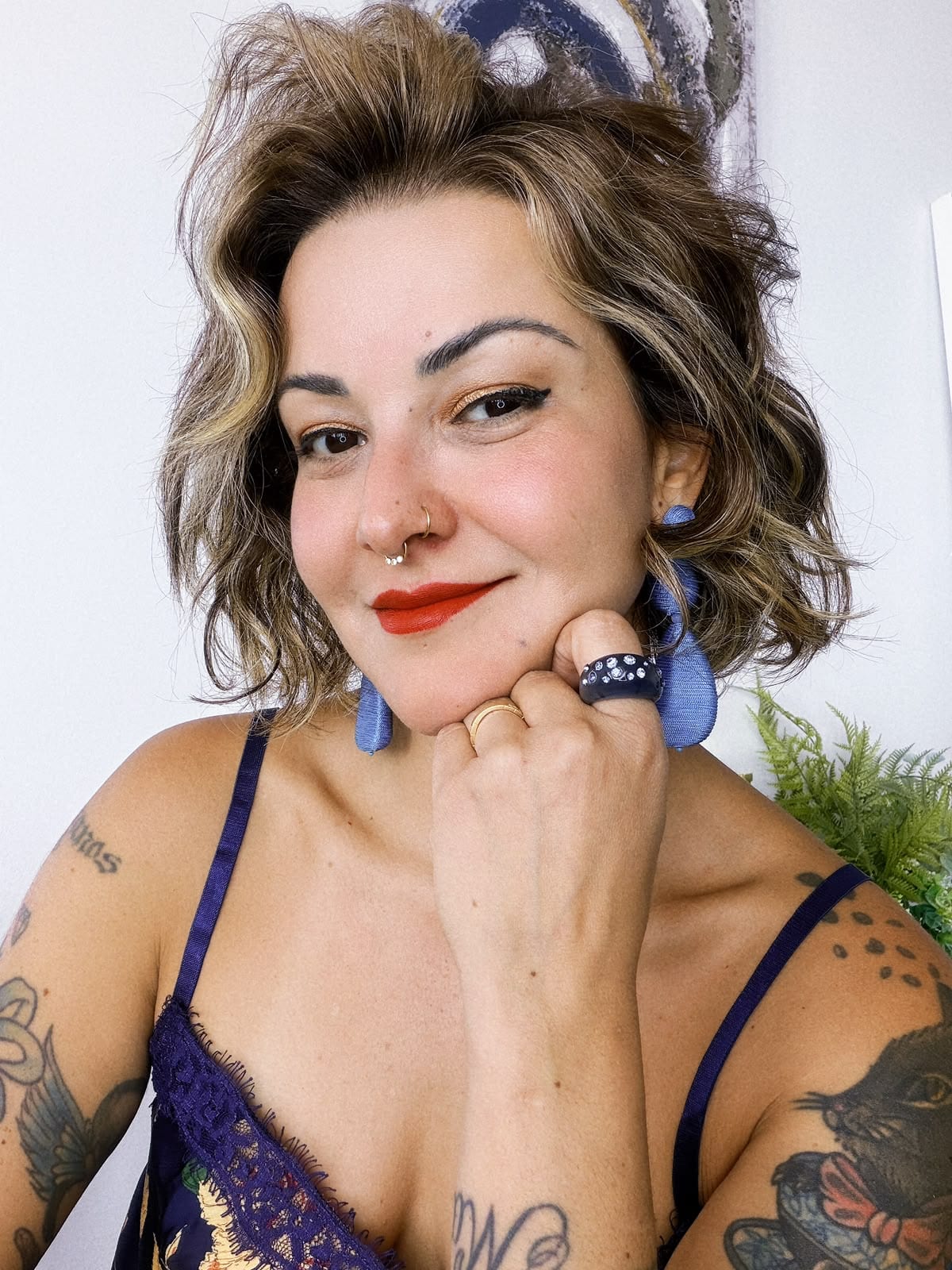 Erika Barros resting her chin on her hand, with a painting in the background